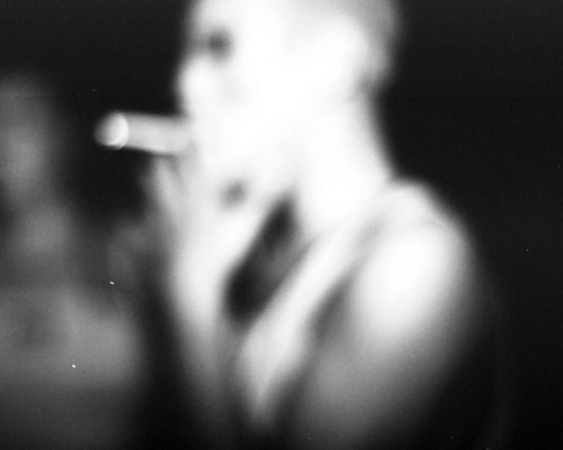 Silhouette floue, cigarette, lumière blanche.
